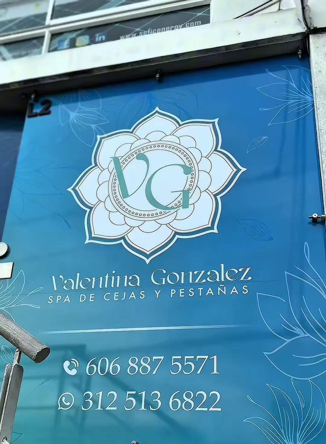 Fachada azul de Valentina Gonzalez Spa con el loto VG, en Guayacanes, Manizales